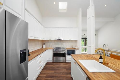 une cuisine avec des armoires blanches et un comptoir en bois dans l'établissement Acreage Estate -Mini Horses -Outdoor Spa -Tennis Court, à Holgate