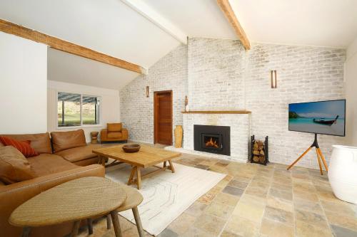 un salon avec un canapé et une cheminée dans l'établissement Acreage Estate -Mini Horses -Outdoor Spa -Tennis Court, à Holgate