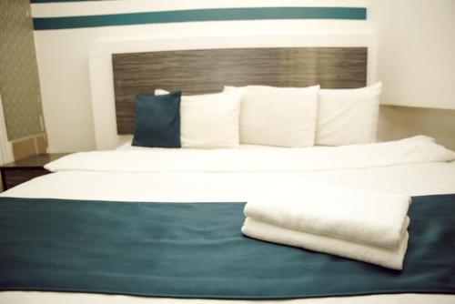 a bedroom with a large bed with blue and white pillows at V Hotel Titiwangsa in Kuala Lumpur