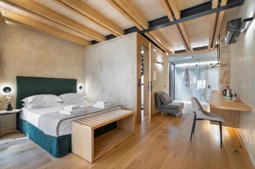 een slaapkamer met een bed, een bureau en een stoel bij Poem Suites in Chania