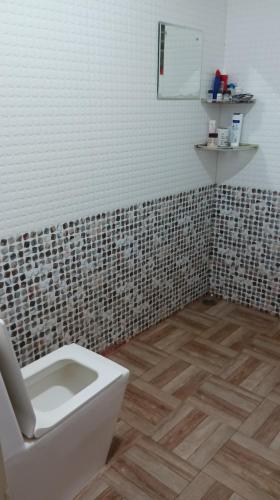 a bathroom with a toilet and a tiled wall at Avaredhalu Homestay in SanivÄrsante