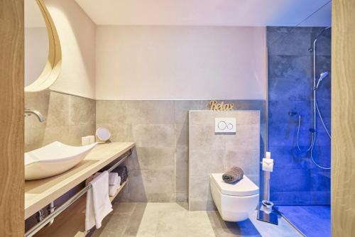 a bathroom with a toilet and a sink and a shower at Mountain Living Ski-in & Ski out Silvretta Sommer Card Including in See