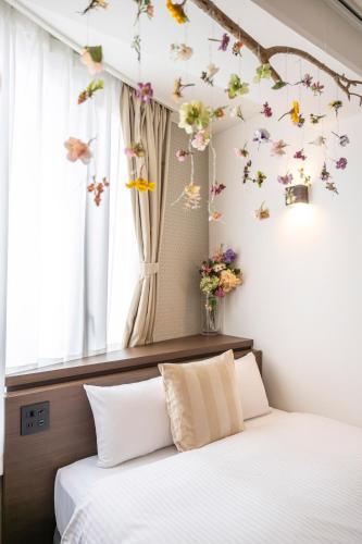 a bedroom with a bed with butterflies on the wall at TapStay Hotel in Saga