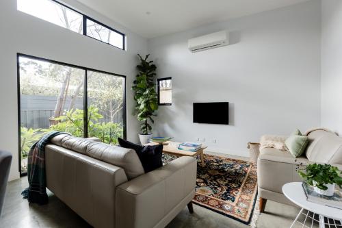 a living room with a couch and a tv at Marri Lodge - 2 Bedroom with Ensuites Spacious Townhouse in Margaret River Town