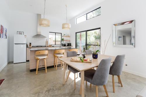 a kitchen and dining room with a wooden table and chairs at Marri Lodge - 2 Bedroom with Ensuites Spacious Townhouse in Margaret River Town