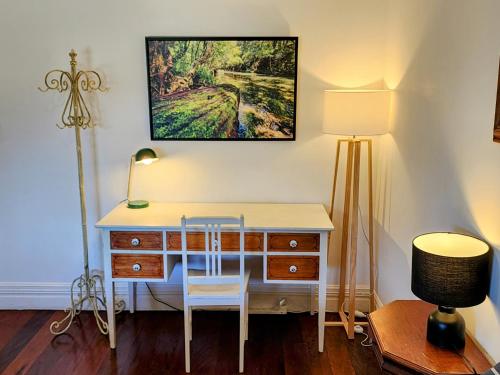 a desk with a chair and a table and a lamp at Bellingen Belfry Guesthouse in Bellingen
