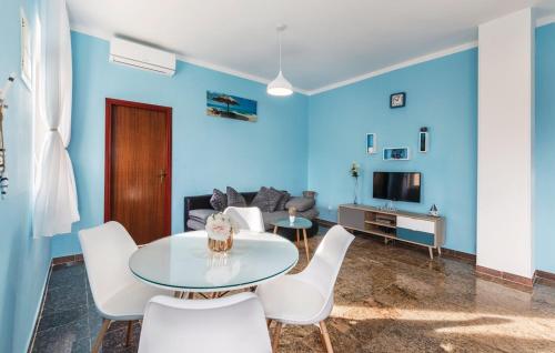a blue living room with a table and white chairs at Apartments Armin in Ližnjan