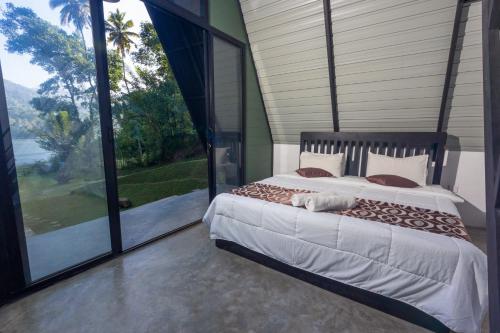 Postel nebo postele na pokoji v ubytování Kandy, River Moon Cabin