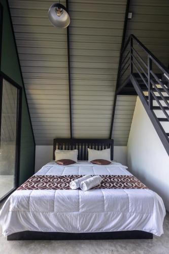 a bedroom with a large bed with a staircase at Kandy, River Moon Cabin in Kandy