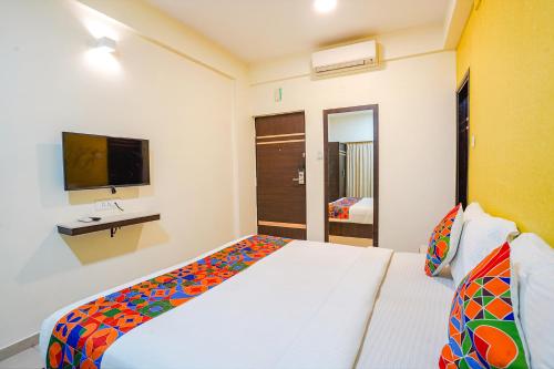 Un dormitorio con una cama blanca y un televisor. en FabHotel Sky View Palace - Marathahalli Outer Ring Road, en Bangalore