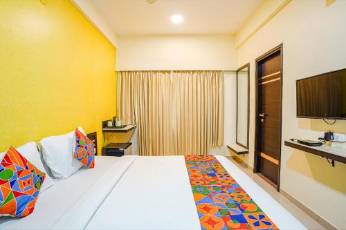 una habitación de hotel con una cama y un televisor en FabHotel Sky View Palace - Marathahalli Outer Ring Road, en Bangalore