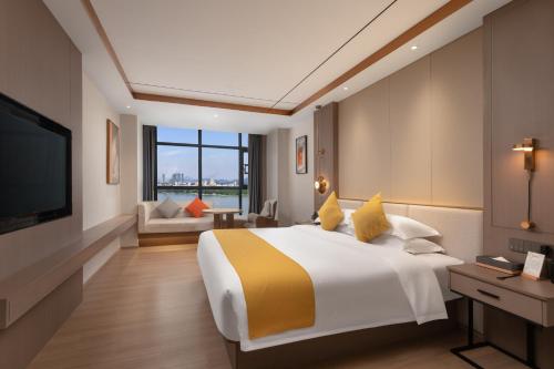 潮州Poltton International Hotel - Chaozhou Hanjiang的配有床和电视的酒店房间