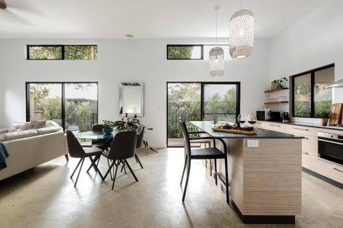 a kitchen and living room with a table and chairs at Peppi Place - 2 Bedroom with Ensuites Town Villa in Margaret River Town