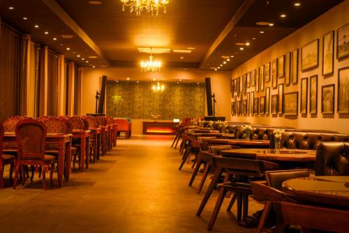 a dining room with tables and chairs and a chandelier at Ulaanbaatar Hotel in Ulaanbaatar