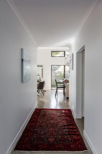 a hallway with a red rug on the floor at Peppi Place - 2 Bedroom with Ensuites Town Villa in Margaret River Town