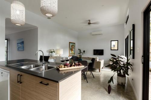 a kitchen with a sink and a living room at Peppi Place - 2 Bedroom with Ensuites Town Villa in Margaret River Town