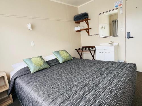 a bedroom with a bed with two pillows on it at Seagulls Guesthouse in Mount Maunganui