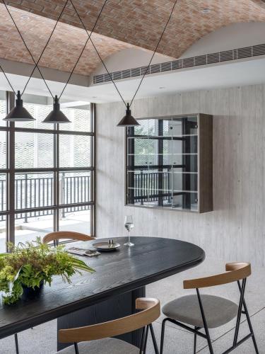 a dining room with a black table and chairs at H suite inn in Changhua City