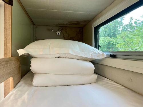 a pile of pillows in a room with a window at Zhangjiajie Cliff Flower RV Tent Hotel in Sanguansi