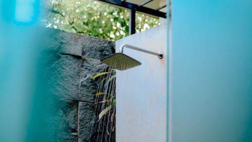 a garden rake hanging on a stone wall at Zifana Private Villa - West Lombok in Lembuak