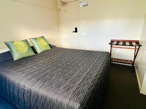 a bedroom with a large bed with two pillows at Seagulls Guesthouse in Mount Maunganui