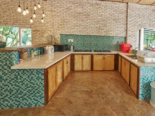 a large kitchen with wooden cabinets and a brick wall at Lakeview Gardens in Xóm Ðá Dủng