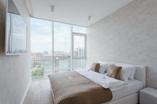 a bedroom with a bed with a large window at Prestige Plaza Apartments in Odesa