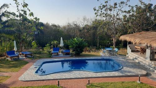 a swimming pool in a yard with chairs and a table at Corsita Resort Koh Mak in Ko Mak
