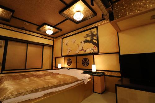 a bedroom with a bed and a painting on the wall at ホテル三愛 in Himeji