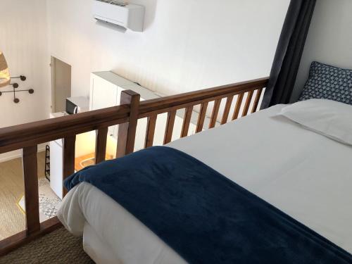 a bedroom with a bed with a blue blanket at LES LOGES DE BACCHUS Le Carpe Diem in Chonas-lʼAmballan