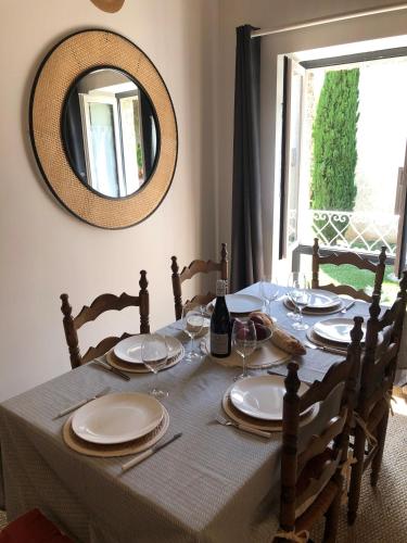 a table with plates and wine glasses and a mirror at LES LOGES DE BACCHUS Le Carpe Diem in Chonas-lʼAmballan