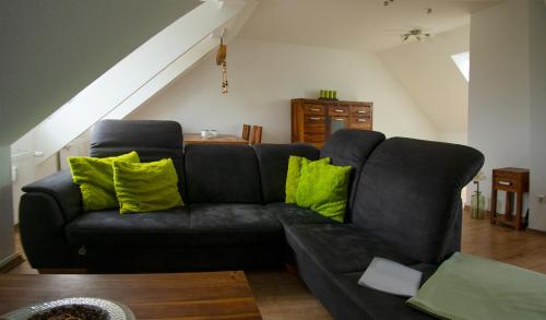a black couch with lime green pillows in a living room at Rauszeit in Böhlen