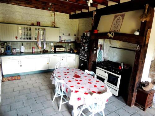 une cuisine avec une table et une cuisine avec une cuisinière dans l'établissement En route pour la Sélinière !, à Champ-du-Boult