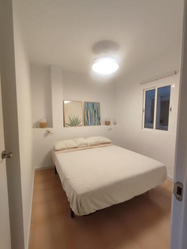 a bedroom with a bed in a white room at Apartments Kione Playa Romana Park in Alcossebre