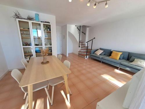 a living room with a table and a blue couch at Apartments Kione Playa Romana Park in Alcossebre