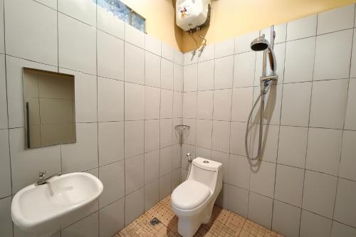 a bathroom with a shower and a toilet and a sink at Hotel New Dieng By Helocus in Berastagi