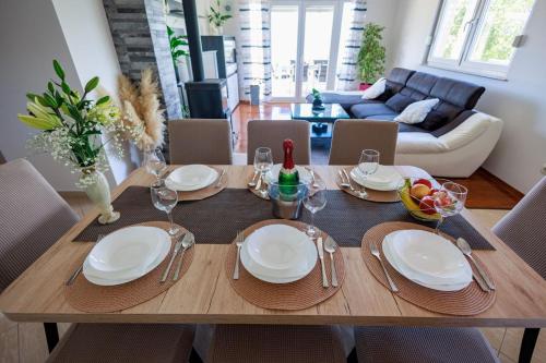 a dining room table with plates and glasses on it at Perfect holiday in Vila Hany home in Šestanovac