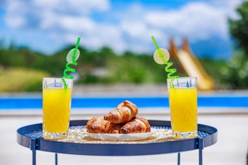 two glasses of orange juice and a plate of pastries at Perfect holiday in Vila Hany home in Šestanovac
