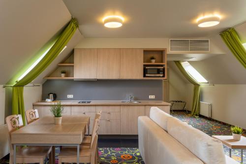 a kitchen and living room with a couch and a table at City Hotels Rūdninkai in Vilnius