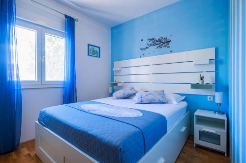 a blue bedroom with a bed with blue walls at Perfect holiday in Vila Hany home in Šestanovac