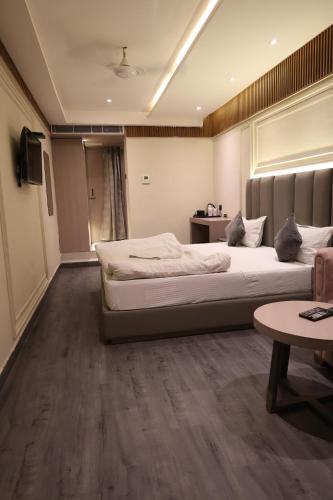 a bedroom with two beds and a television in it at Hotel Gagan Suite in Kānpur