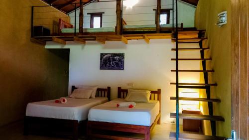 Zimmer mit 2 Betten und einer Wendeltreppe in der Unterkunft Sigiriya Elephant Villa in Sigiriya