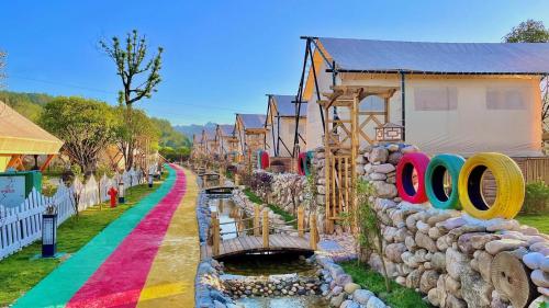 a row of houses with a rainbow painted street at Zhangjiajie Cliff Flower RV Tent Hotel in Sanguansi