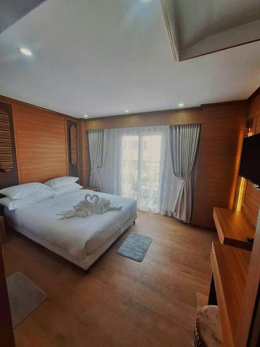 a bedroom with a large bed and a large window at V.I.P BOUTIQUE HOTEL in Vientiane