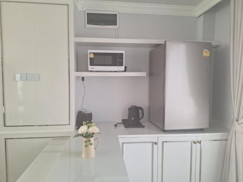 a kitchen with a table with a microwave and a vase of flowers at V.I.P BOUTIQUE HOTEL in Vientiane