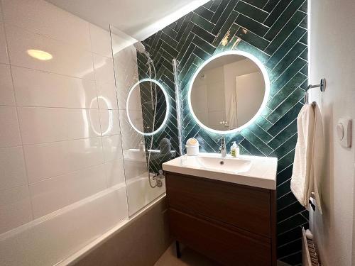 une salle de bain avec un lavabo et un miroir dans l'établissement Charmant appart avec vue sur lac, à Savigny-le-Temple