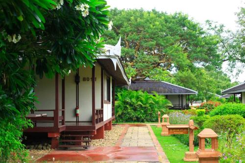 a garden with a bench and a house at Bagan Thiripyitsaya Sanctuary Resort in Bagan