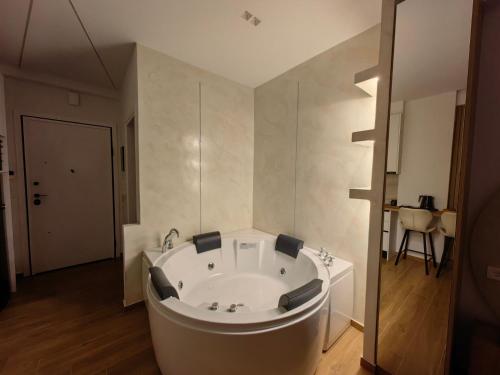 a large white tub in a bathroom with wooden floors at City break 1 LeD & Bath in Volos