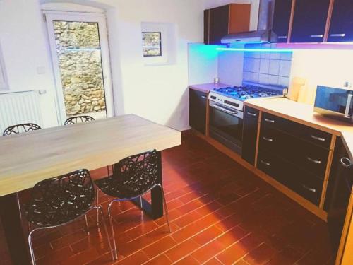 - une cuisine avec une table en bois et une cuisinière dans l'établissement Spacieuse maison de village de caractère pour 10 personnes, à Saint-André-de-Roquepertuis