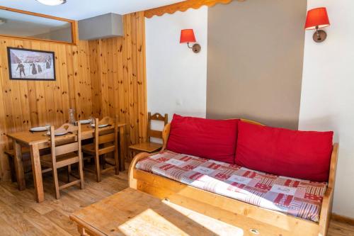 une chambre avec un lit et une table avec un oreiller rouge dans l'établissement Résidence Les Hauts De Preclaux - Appartement avec vue sur les pistes MAE-7591, aux Orres